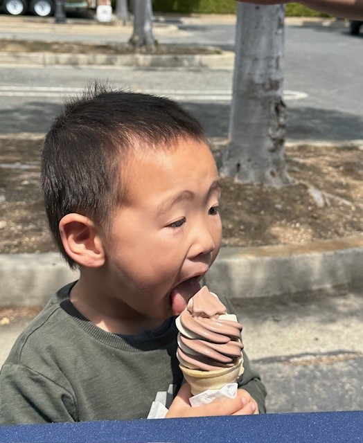 little boy enjoying ice cream received by visiting booths at STEM 2025